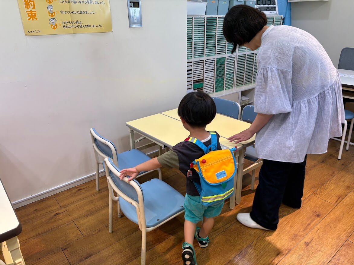 席に座る息子、先生